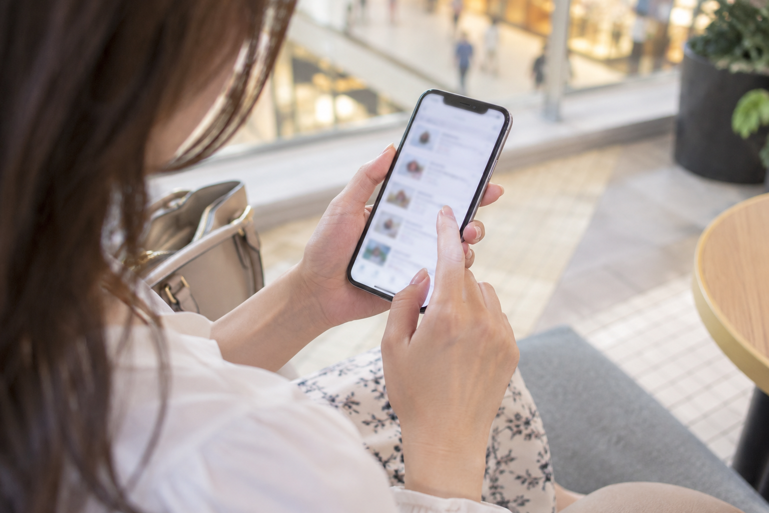 外出先でスマートフォンから訪問先を確認する女性のイメージ
